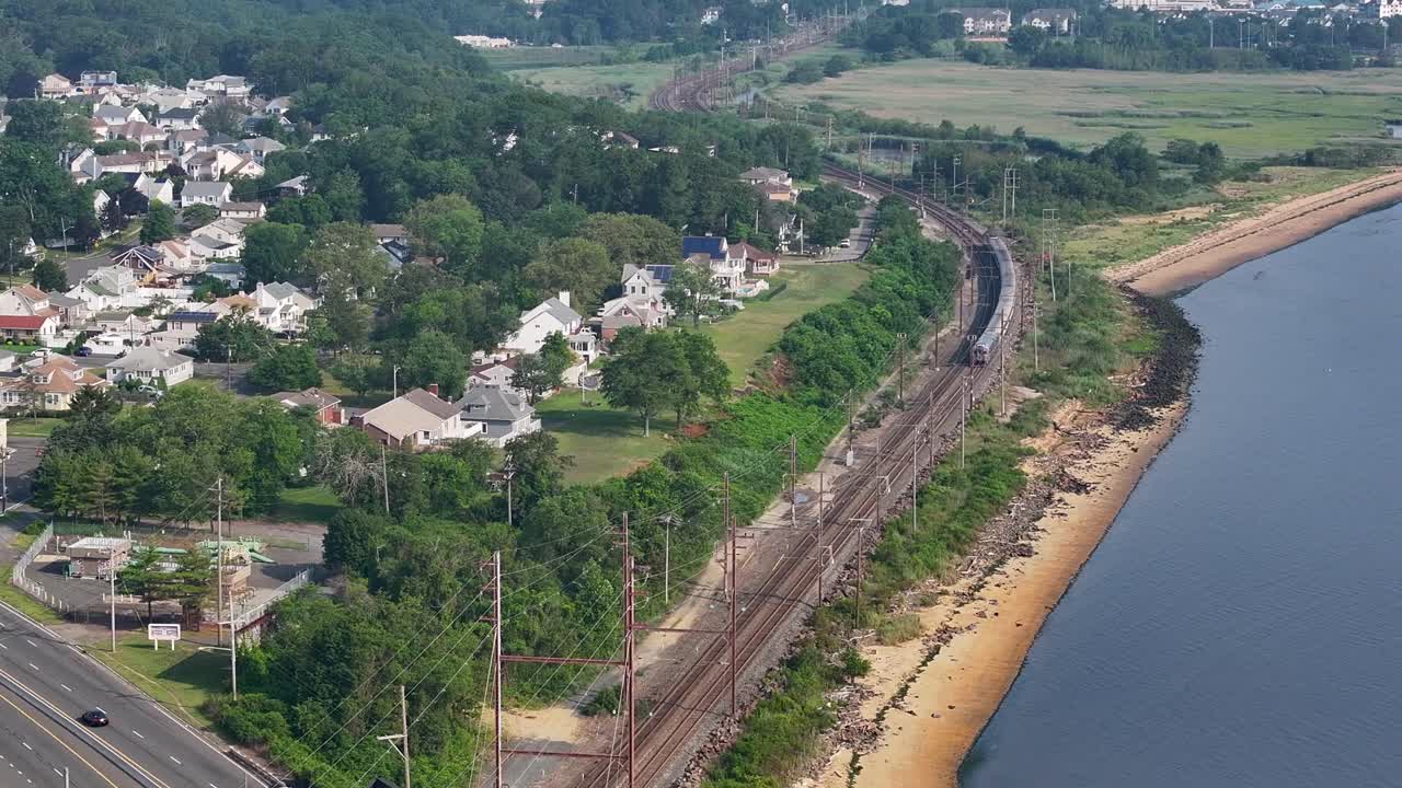 un tren redondeando la curva a lo largo de la bahía de raritan en morgan, nueva jersey