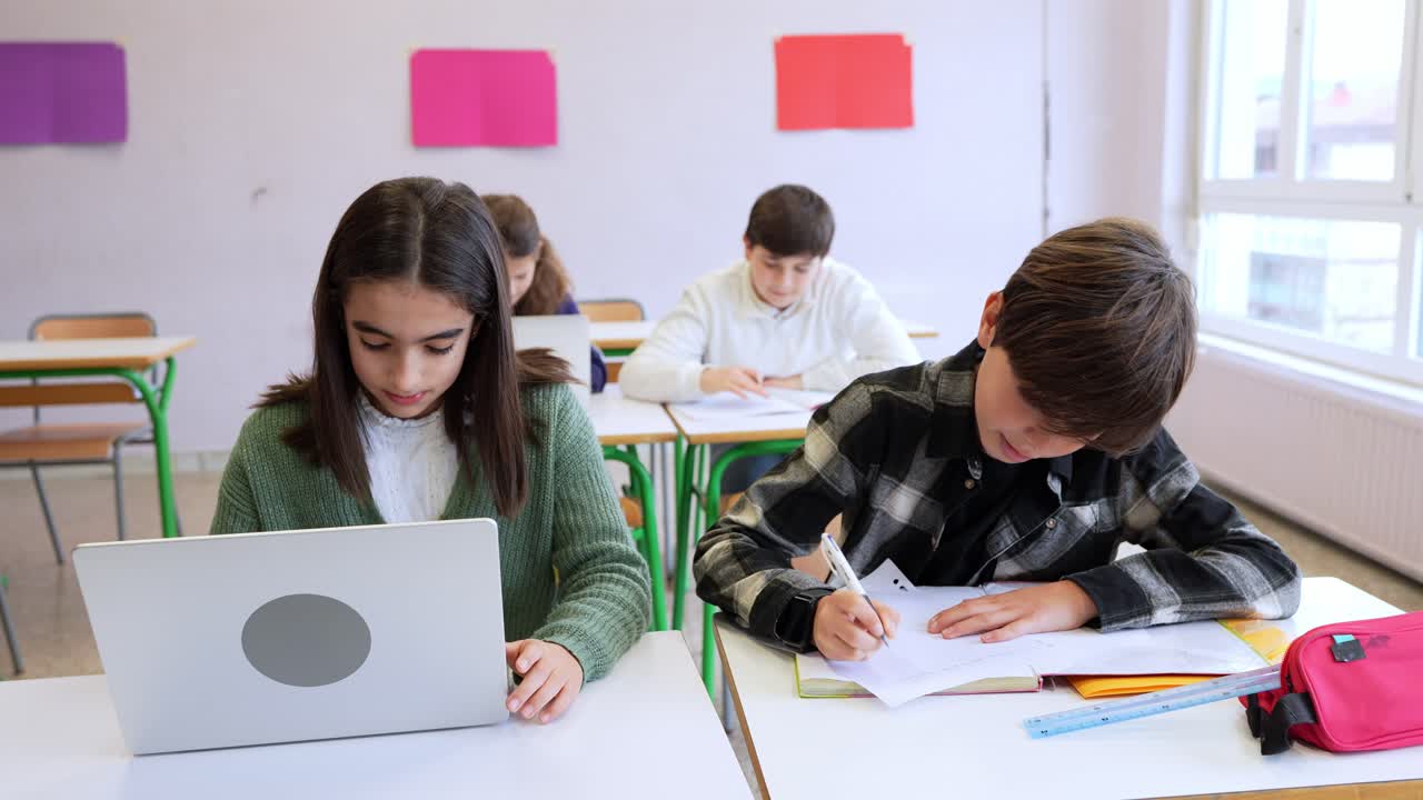 Estudiantes aprendiendo y trabajando con portátiles en un aula