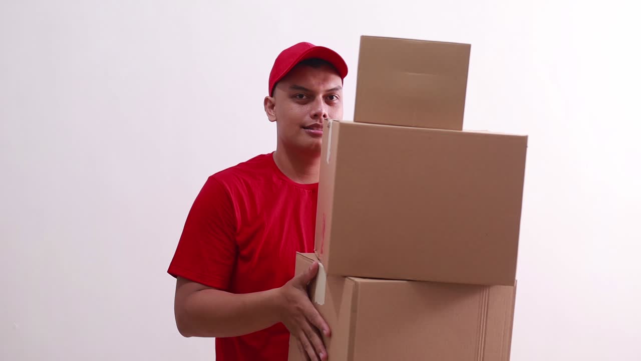 joven mensajero asiático de pie mientras sostiene una caja de cartón