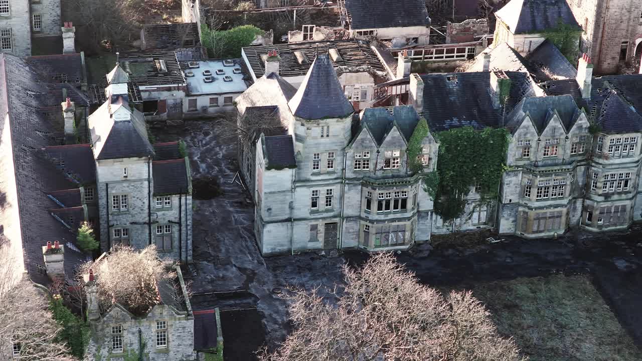 Vista aerea della tenuta psichiatrica vittoriana dell'ex manicomio di Denbigh, che sorvola il tetto fatiscente e inquietante dell'edificio.