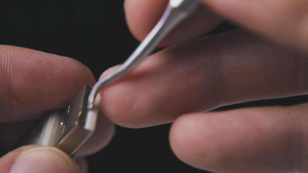 hombre limpia el enchufe usb con gancho de metal sobre fondo negro