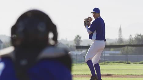 caucasian female baseball player wearing glasses pitching ball on baseball field