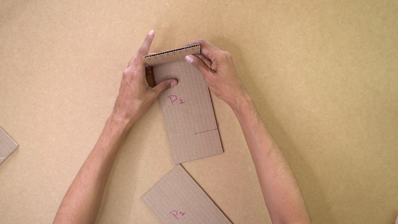 Person putting together cardboard pieces by following instructions and order