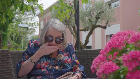 grandmother reading outdoors in french retirement home