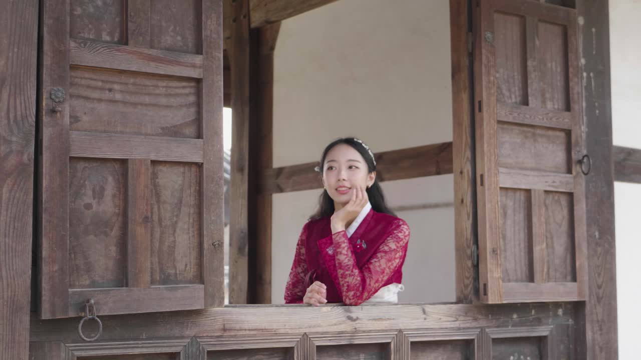 Giovane modella sorridente in Hanbok in una casa tradizionale coreana