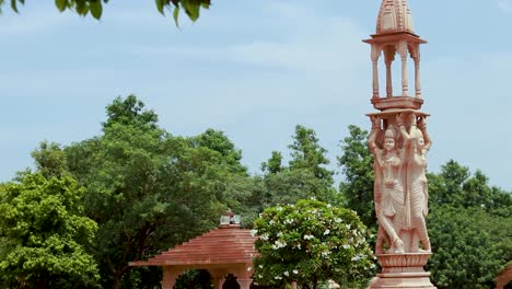 artistic-red-stone-jain-god-holy-pillar-at-morning-from-unique-angle-video-is-taken-at-Shri-Digamber-Jain-Gyanoday-Tirth-Kshetra,-Nareli,-Ajmer,-Rajasthan,-India