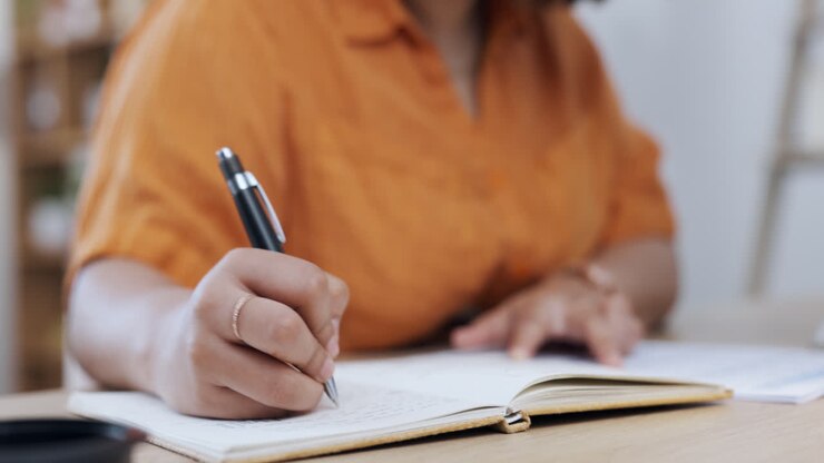 Closeup, hand and notebook for planning