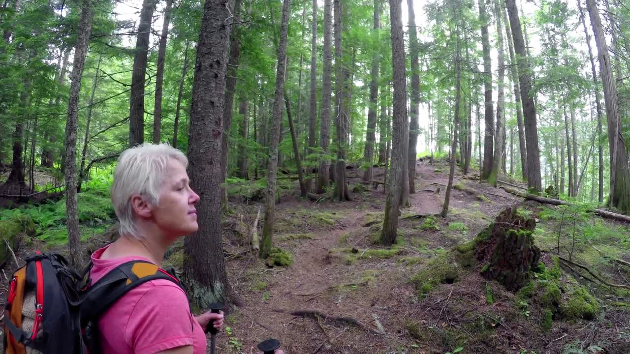 mujer madura de pie en el bosque 4k
