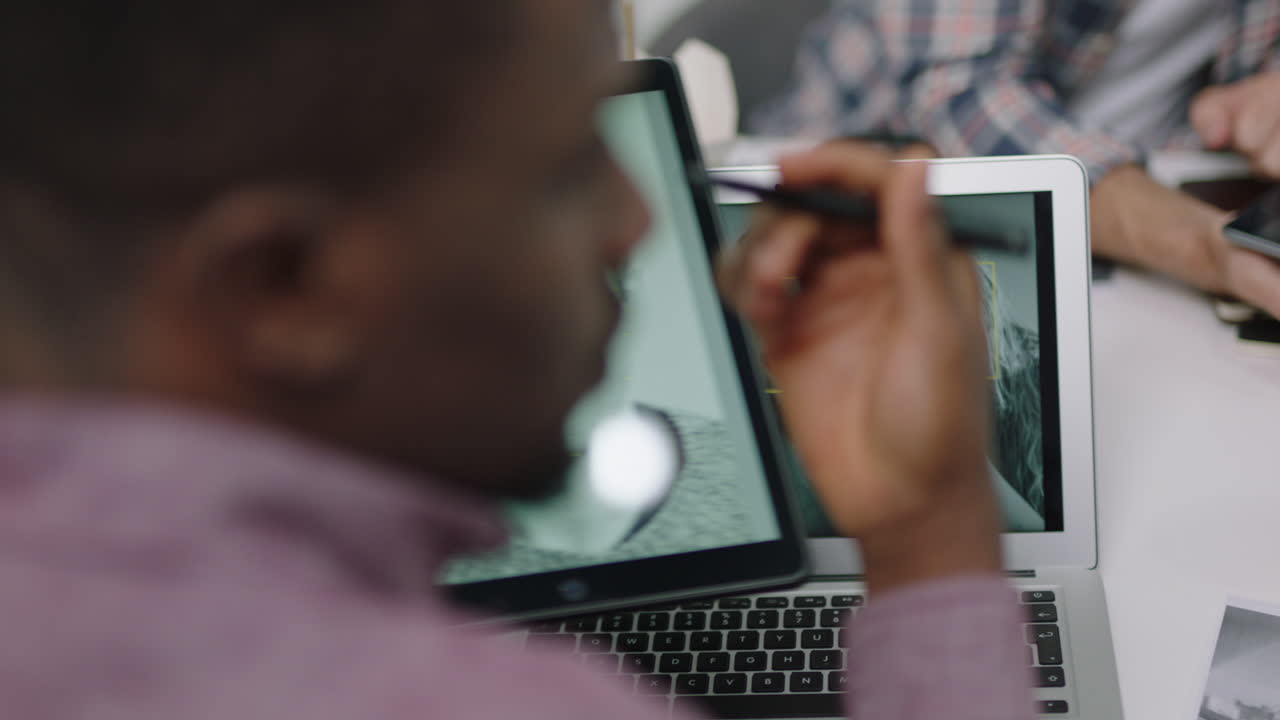 group of engineers developing facial recognition software technology using digital tablet computer brainstorming design solution sharing project ideas in busy office meeting