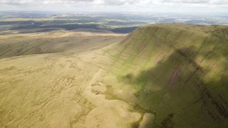 Sombras-De-Nubes-Pasando-Sobre-Brecon-Beacons-Llyn-Y-Fan-Fach-Verdes-Montañas-Valle-Aéreo-Hacia-Adelante-En-Movimiento