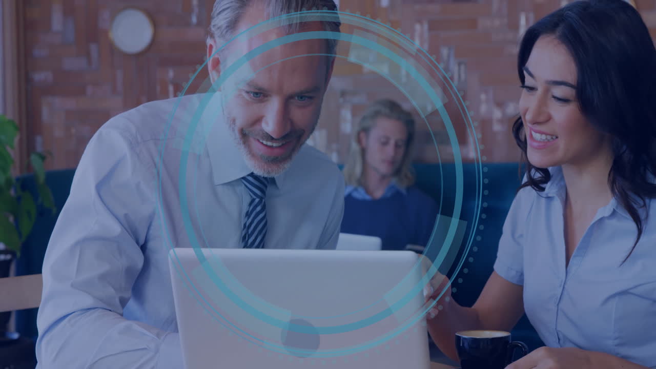 Collaborating on laptop, business professionals analyzing digital data in office setting