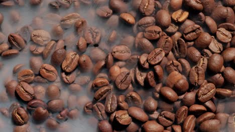 Close-up-of-seeds-of-coffee.-Fragrant-coffee-beans-are-roasted-smoke-comes-from-coffee-beans.