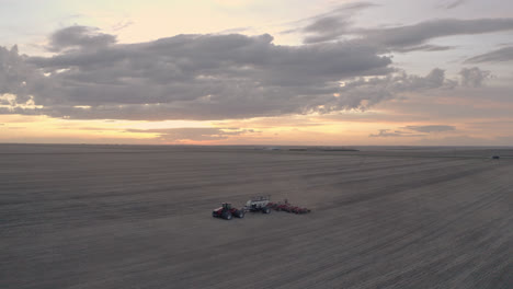 Paralaje-Aéreo-Alrededor-Del-Campo-De-Siembra-De-Tractores-Solitarios-En-Saskatchewan,-Canadá