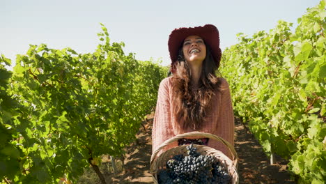 mujer con una canasta de uvas en las manos riendo