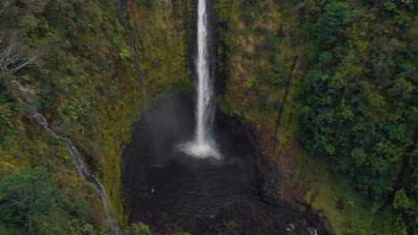 tilt shot of giant beautiful waterfall in tropical rain forest hanakapiai falls, kauai, hawaii  4k aerial view drone