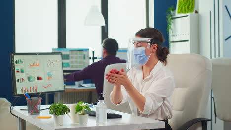 entrepreneur with protection mask applying sanitizer gel on hands