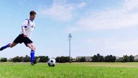 football player kicking a ball in the field