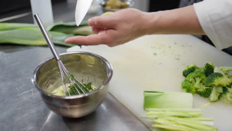 chef mixing sauce with dill
