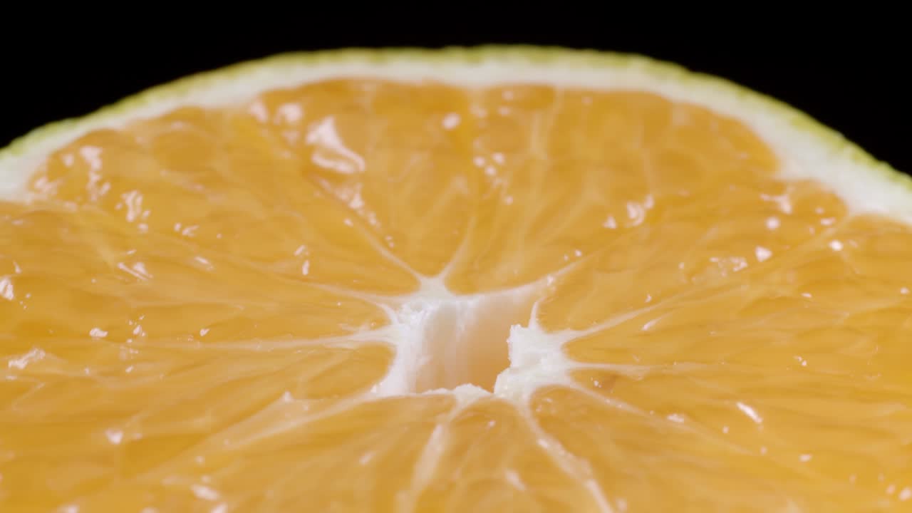 Video di mandarino affettato che ruota su sfondo nero