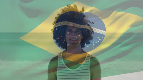 animation of waving flag of brazil over biracial man standing against ocean at beach