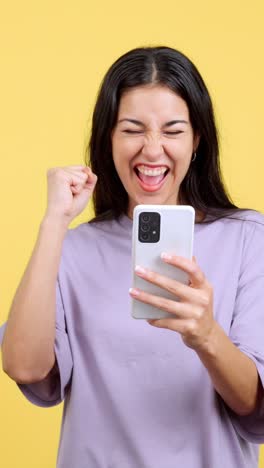 excited woman celebrating success on smartphone