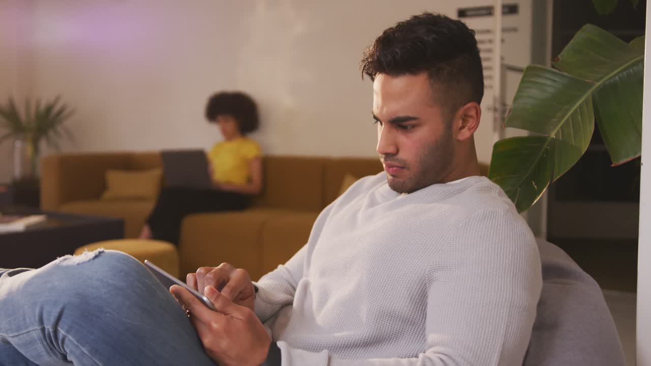 Mixed race man on smartphone in creative office