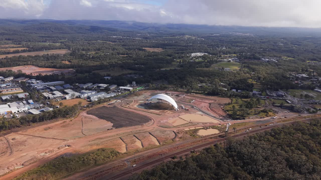 Aerial establishing approach to Cedar Mill abandoned stadium site with dirt roads and unfinished work