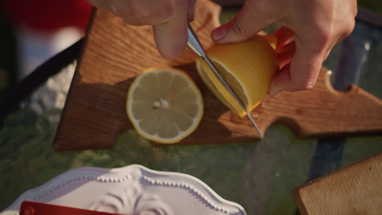 Trozos de limón amarillo brillante sobre una mesa rústica. Elegantes gajos de limón dispuestos en un plato de porcelana al aire libre. Rodajas de limón recién cortadas sobre una mesa rústica con colores vivos y condensación.