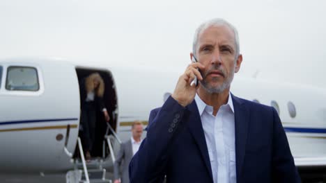 hombre de negocios hablando por teléfono móvil en la terminal 4k