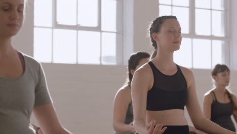 Joven-Mujer-Caucásica-Embarazada-En-Clase-De-Yoga-Practicando-Postura-De-Loto-Disfrutando-De-La-Práctica-De-Meditación-En-Grupo-Relajándose-En-El-Gimnasio-Al-Amanecer.