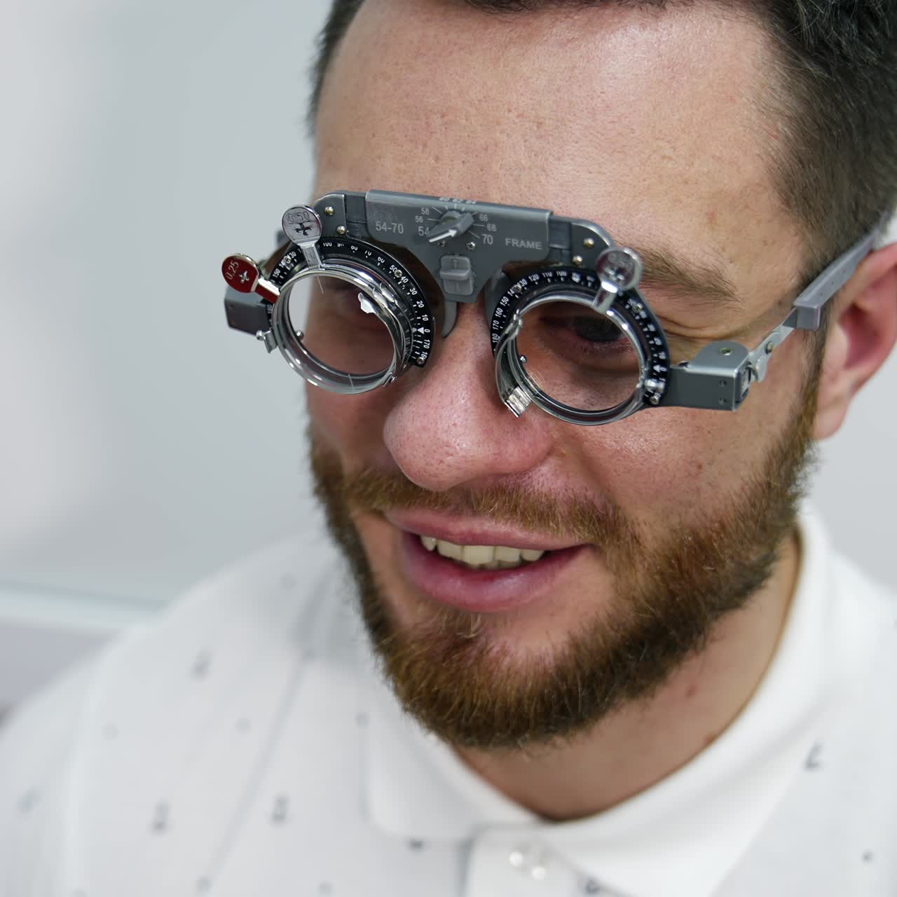 Handsome man at ophthalmology clinic. Special testing glasses with replacable lenses for vision correction on a male patient