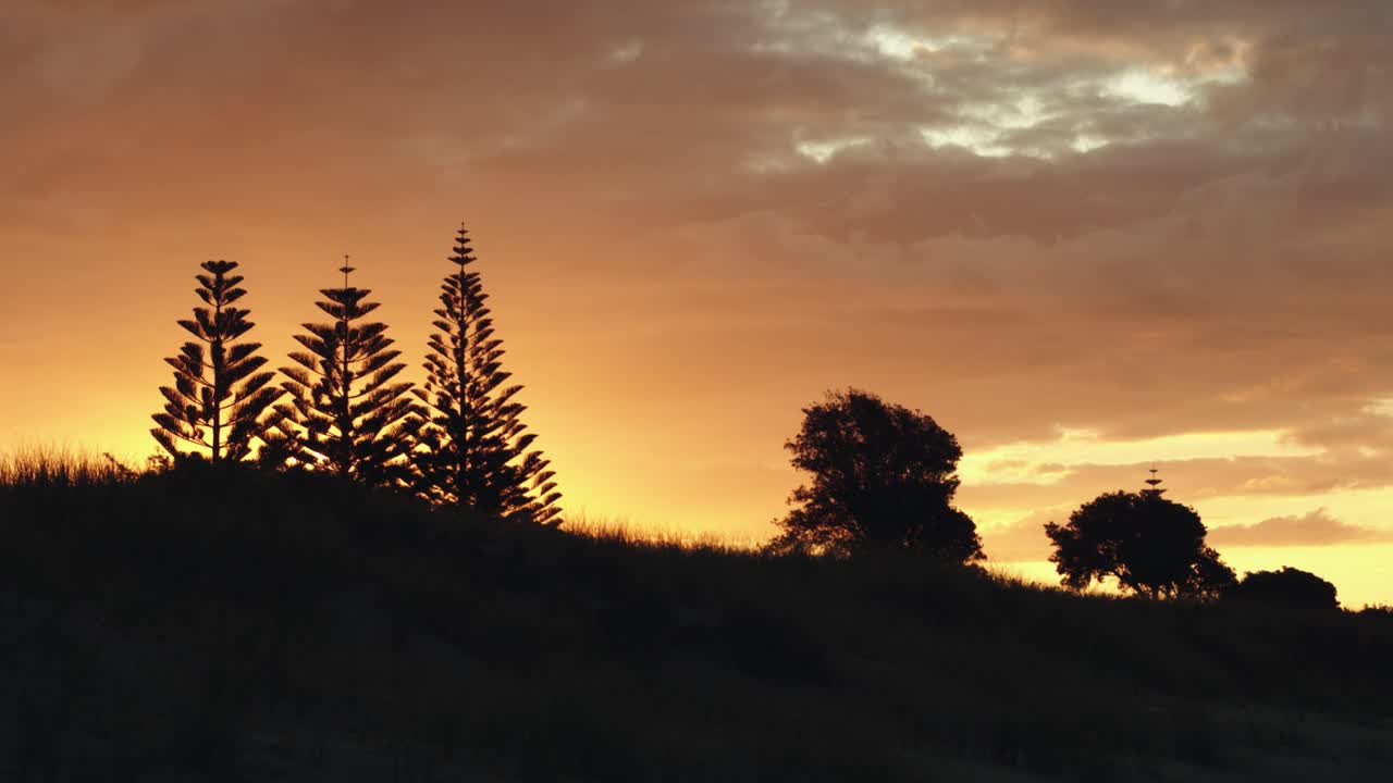 silueta de un panorama rural con un cielo naranja durante la puesta de sol