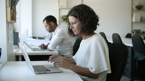 Thoughtful-Caucasian-woman-working-with-laptop