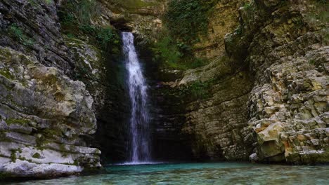 cascada de cuento de hadas con agua limpia y fría que cae en un estanque esmeralda rodeado de acantilados en albania