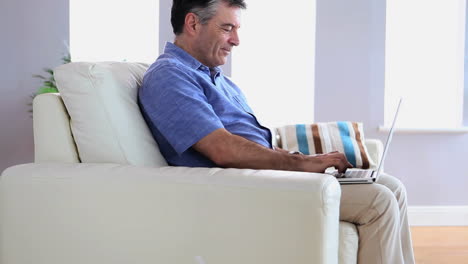 Reifer-Mann-Auf-Dem-Sofa-Mit-Seinem-Laptop