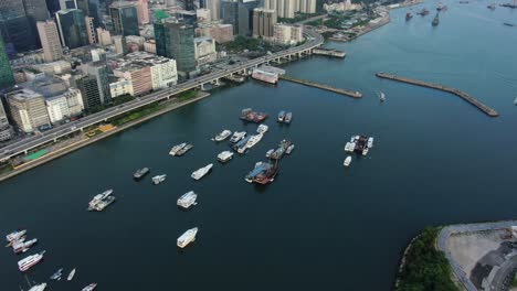 hong kong marina with anchored boats and kwun tong area buildings, aerial view