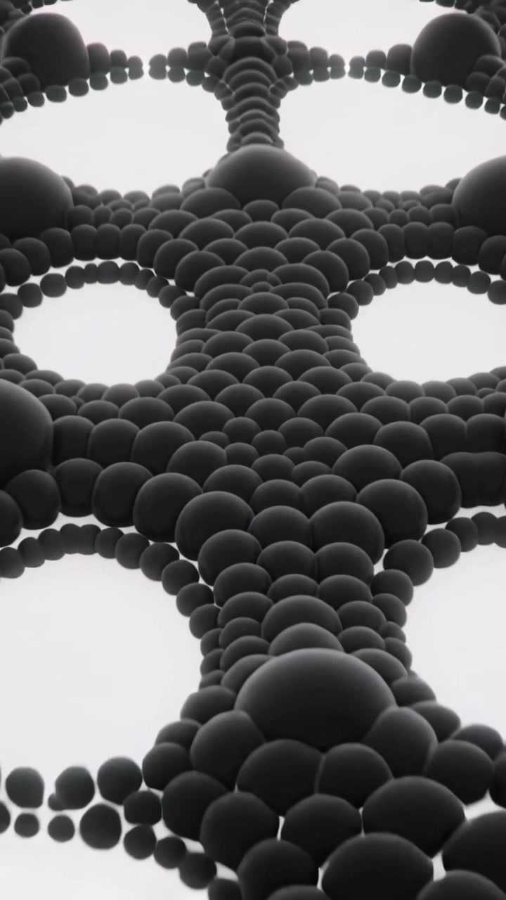 Vertical video: Pulling back camera revealing glossy black spheres forming lattice on white plane