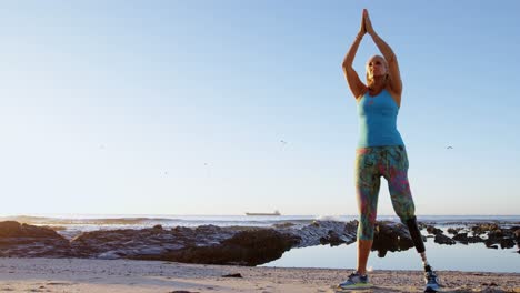 disabled woman performing yoga in the beach 4k