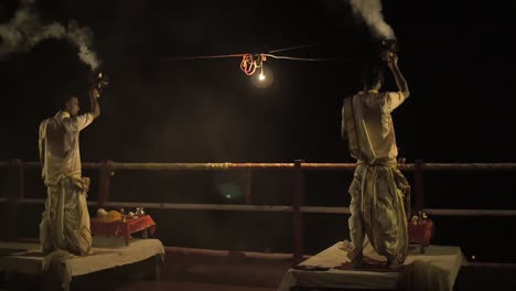 panning shot of men burning incense at night