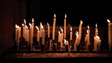 Velas-Encendidas-En-Un-Estante-De-Velas-Votivas-Dentro-De-La-Iglesia