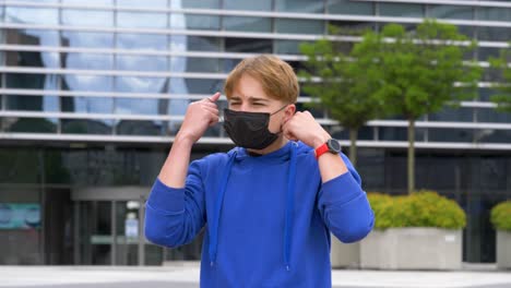 Der-Junge-Teenager-Nimmt-Die-Gesichtsmaske-Im-Zentrum-Der-Stadt-Schwer-Ab