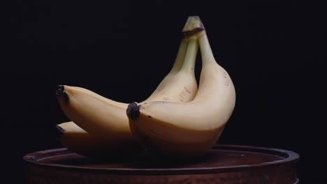 bananas on rotating stand with moody lighting