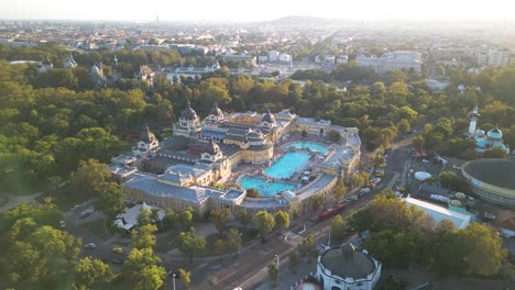 aerial pullback reveals szechenyi thermal baths in budapest city park