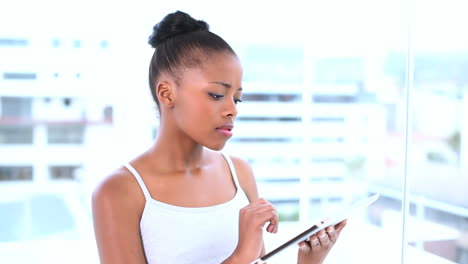 thoughtful natural model using her tablet computer