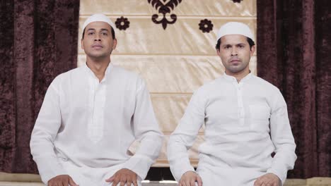 muslim men adjusting caps for ramadan prayer