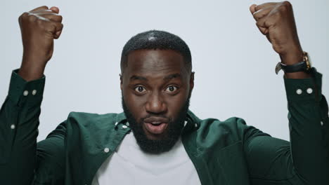 Portrait-of-happy-african-american-man-celebrating-victory-on-grey-background.