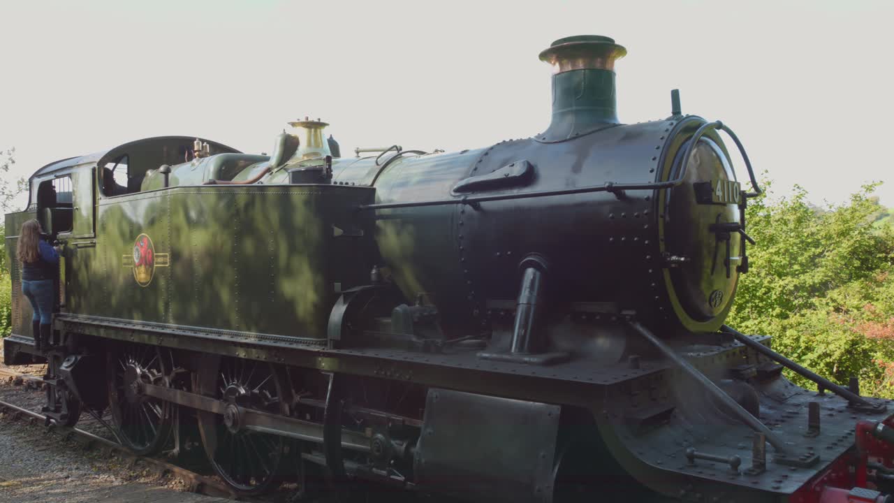 Woman Inspecting a Vintage Steam Train