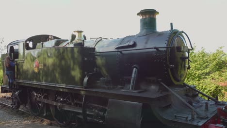 woman inspecting a vintage steam train