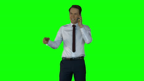 Irritated-businessman-having-phone-call-on-green-screen-