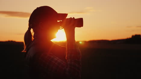 una mujer mirando a través de binoculares en el concepto de viaje y safari al atardecer video 4k